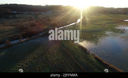 Prés humides de Ravening dans le sud du Jutland, Danemark où un long pont en chêne traverse la rivière Vejle et de basses prairies pendant l'âge des Vikings (980 après J.-C.) Banque D'Images