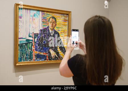 Un visiteur prend une photo de « Portrait de l'Elf dans la clinique » lors d'un aperçu de l'exposition Morgan Stanley : Edvard Munch - chefs-d'œuvre de Bergen dans la galerie Courtauld, Somerset House, Londres. L'exposition présente 18 peintures qui offrent un aperçu du développement artistique de Munch, dont beaucoup sont exposées au Royaume-Uni pour la première fois. Date de la photo: Jeudi 26 mai 2022. Banque D'Images