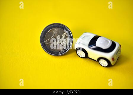 deux pièces de monnaie d'un euro avec une petite voiture-jouet Banque D'Images