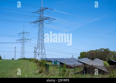 Des lignes électriques avec des pylônes et une centrale solaire vus en Allemagne Banque D'Images