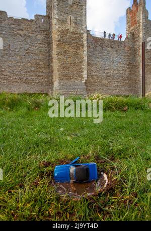 Une voiture bleue en avant-plan, derrière le château de Framingham datant du 13th siècle, Suffolk Banque D'Images