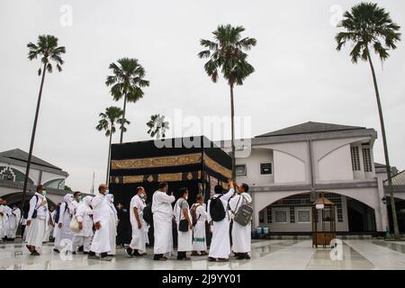 Bandung, Indonésie. 26th mai 2022. Les musulmans indonésiens simulent le contournement d'une Kaaba factice dans le cadre des préparatifs avant leur pèlerinage de Hajj à Bandung. Le Hadj est l'un des cinq piliers de l'islam et est exécuté par tous les musulmans du monde au moins une fois dans leur vie. Crédit : SOPA Images Limited/Alamy Live News Banque D'Images