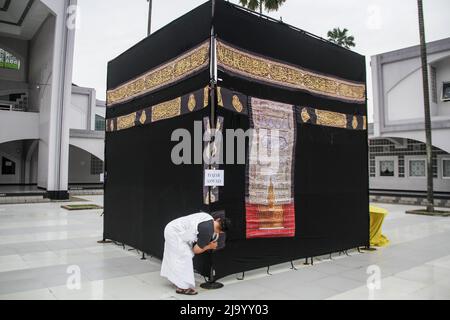 Bandung, Indonésie. 26th mai 2022. Les musulmans indonésiens simulent le contournement d'une Kaaba factice dans le cadre des préparatifs avant leur pèlerinage de Hajj à Bandung. Le Hadj est l'un des cinq piliers de l'islam et est exécuté par tous les musulmans du monde au moins une fois dans leur vie. Crédit : SOPA Images Limited/Alamy Live News Banque D'Images