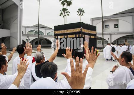 Bandung, Indonésie. 26th mai 2022. Les musulmans indonésiens simulent le contournement d'une Kaaba factice dans le cadre des préparatifs avant leur pèlerinage de Hajj à Bandung. Le Hadj est l'un des cinq piliers de l'islam et est exécuté par tous les musulmans du monde au moins une fois dans leur vie. Crédit : SOPA Images Limited/Alamy Live News Banque D'Images