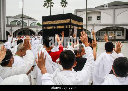 Bandung, Indonésie. 26th mai 2022. Les musulmans indonésiens simulent le contournement d'une Kaaba factice dans le cadre des préparatifs avant leur pèlerinage de Hajj à Bandung. Le Hadj est l'un des cinq piliers de l'islam et est exécuté par tous les musulmans du monde au moins une fois dans leur vie. Crédit : SOPA Images Limited/Alamy Live News Banque D'Images