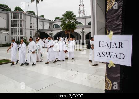 Bandung, Indonésie. 26th mai 2022. Les musulmans indonésiens simulent le contournement d'une Kaaba factice dans le cadre des préparatifs avant leur pèlerinage de Hajj à Bandung. Le Hadj est l'un des cinq piliers de l'islam et est exécuté par tous les musulmans du monde au moins une fois dans leur vie. Crédit : SOPA Images Limited/Alamy Live News Banque D'Images