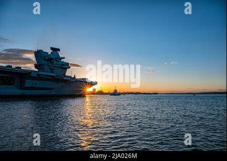 Le porte-avions Queen Elizabeth arrive dans le port de Portsmouth au coucher du soleil. Banque D'Images