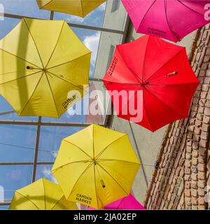 Parasols colorés avec les mots Camden Market font une caractéristique intéressante au-dessus d'une rangée de magasins au marché. Banque D'Images