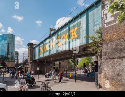 Les habitants et les touristes se promènaient autour du pont emblématique de Camden Lock Railway avec son texte jaune audacieux et instantanément reconnaissable. Banque D'Images