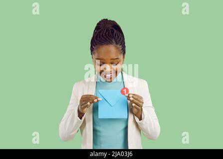 Une femme noire souriante reçoit une notification de nouveau message d'affaires dans son courrier Banque D'Images