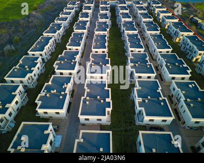 Vue panoramique d'un grand nombre de petits hôtels gris appartements identiques dans une petite ville avec des rues vides et des voitures modernes, entouré par Banque D'Images
