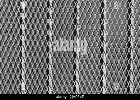 Grille métallique de sécurité robuste protégeant une fenêtre d'entrepôt en noir et blanc. Banque D'Images