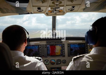 Deux pilotes sur un petit avion charter atterrissant à l'aéroport d'Arusha, Tanzanie, Afrique. Banque D'Images