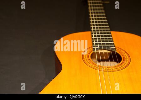 Guitare classique gros plan sur fond sombre. Banque D'Images