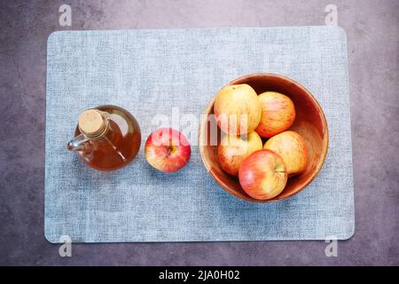 vue de dessus du vinaigre de pomme dans une bouteille de verre avec pomme verte fraîche sur la table Banque D'Images