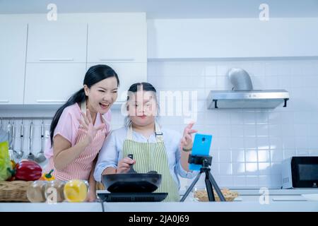 Asiatique personne avec le syndrome de Down cuisiner avec maman. Croissance du cerveau apprentissage famille amour intelligence cuisine Banque D'Images