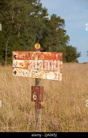 Des panneaux routiers rouillés le long d'une route de terre dans les pampas argentins, près de Las Flores, Argentine. Banque D'Images