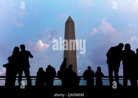 Silhouette de personnes regardant le monument Obélisque sur l'Avenida 9 de Julio, San Nicolas, Buenos Aires, Argentine. Banque D'Images