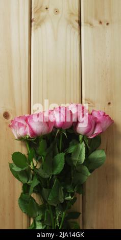 Image verticale de la vue en hauteur d'un bouquet de roses sur des planches en bois Banque D'Images