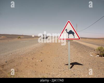 Panneau d'avertissement Camels à côté d'une route au Maroc où se trouve un véhicule tout-terrain Banque D'Images