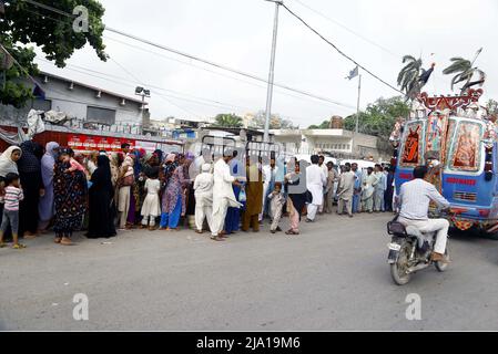 Rawalpindi, Pakistan, 26 mai 2022. Les personnes dans le besoin sont rassemblés dans une file d'attente pour obtenir des aliments de charité fournis par l'organisation caritative en raison de la hausse des prix dans le pays, à l'extérieur de l'hôpital Jinnah à Karachi le jeudi 26 mai 2022. Banque D'Images