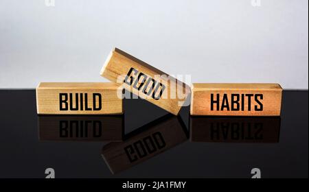 Symbole de bonnes habitudes. Les blocs de bois avec les mots créent de bonnes habitudes. Magnifique arrière-plan noir et blanc, espace de copie. Le concept de l'entreprise, psy Banque D'Images