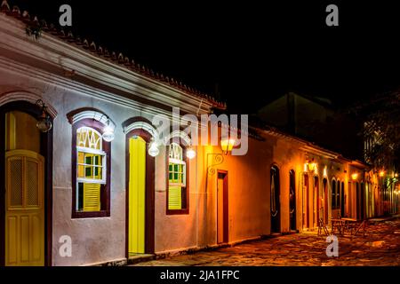 Rue en pierre et maisons de style colonial illuminent la nuit dans la ville de Paraty sur la côte de Rio de Janeiro, Brésil Banque D'Images