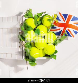 Balles de tennis jaunes dans une boîte en bois et le drapeau de la Grande-Bretagne Banque D'Images