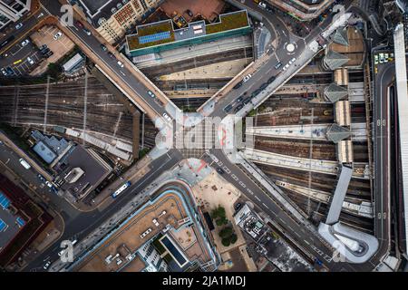 Une vue aérienne directement au-dessus d'une métropole urbaine avec croisement de rue au-dessus de chemins de fer et de métro très fréquentés Banque D'Images