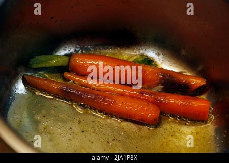 dans une casserole en métal, faire beurre de carottes glacées avec du sel et du poivre Banque D'Images