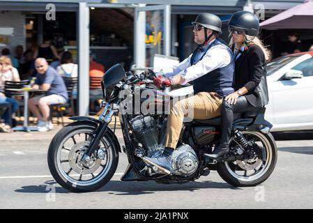 Motocycliste participant à l'événement de moto Distinguished Gentleman's Ride, à bord d'une moto Harley Davidson avec un pillion féminin intelligent en costume et talon Banque D'Images