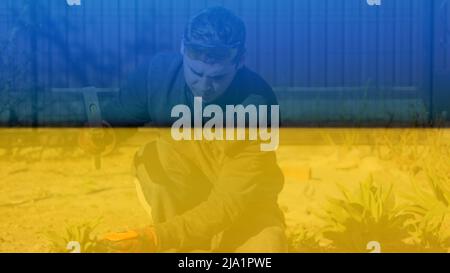 Recentrer les jeunes travailleurs de la construction dans des lunettes jaunes en éliminant les irrégularités sur la table de plancher à l'aide d'un marteau et d'un burin. Mains mâles la dalle de béton. Pati Banque D'Images