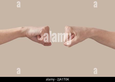Deux mains les mains mâles et femelles s'embuent sur le beige. Banque D'Images