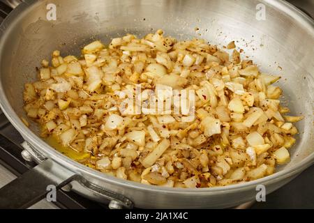 Caramélisation des oignons dans une poêle en acier Banque D'Images
