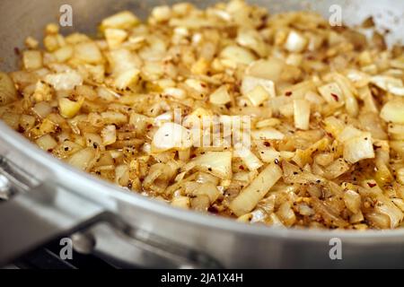 Caramélisation des oignons dans une poêle en acier Banque D'Images