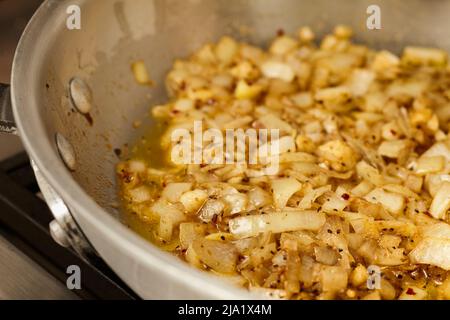 Caramélisation des oignons dans une poêle en acier Banque D'Images