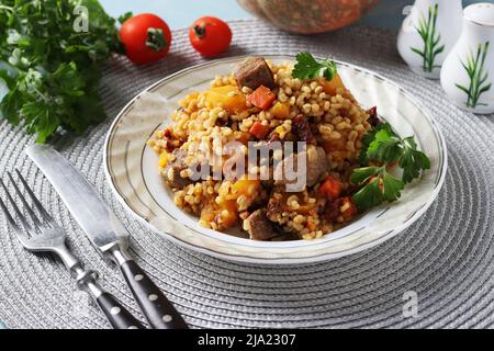 Bœuf avec boulgour et légumes tels que la citrouille, les carottes, les oignons et les tomates séchées, gros plan Banque D'Images