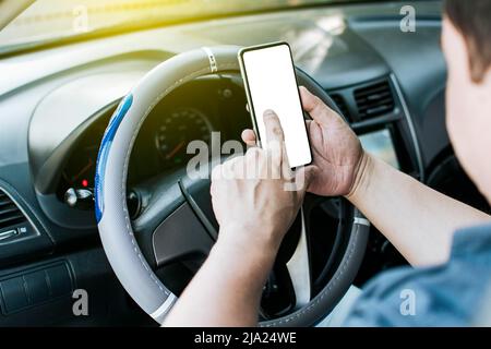 Gros plan des mains du conducteur à l'aide de son téléphone, de la personne dans sa voiture à l'aide d'un téléphone cellulaire, des mains du conducteur concept touchant l'écran du téléphone cellulaire Banque D'Images