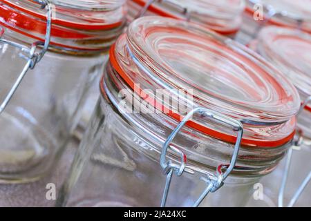 Gros plan de récipients en verre vides ou de récipients de conservation avec anneau d'étanchéité orange en rangée. Concept de conservation des aliments. Banque D'Images