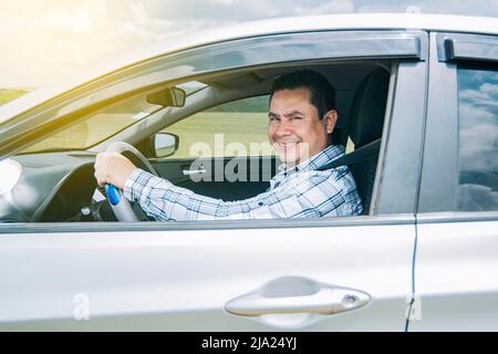 Homme souriant à la caméra dans sa voiture, homme souriant heureux dans sa voiture, image d'une personne souriant et heureux de conduire une voiture et regardant la caméra Banque D'Images