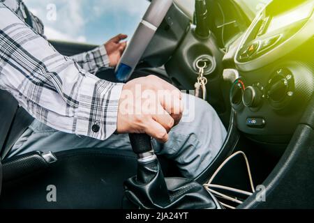 Gros plan de la main d'un homme sur le levier de vitesses d'une voiture, concept de vitesse et levier de vitesses, gros plan des mains accélérant sur le levier de vitesses Banque D'Images