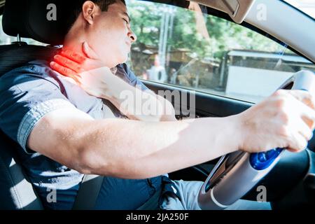 Un conducteur avec douleur de cou, concept d'un homme dans sa voiture avec douleur de cou. Un conducteur épuisé avec douleur au cou dans la circulation, Une personne avec douleur au cou dans la circulation Banque D'Images