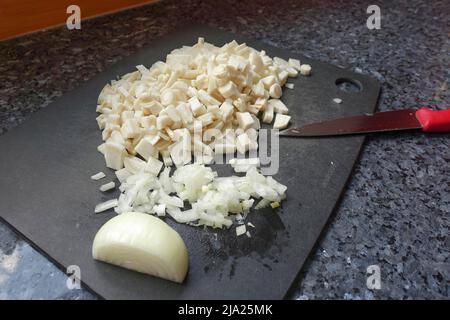 Cuisine souabe, préparation racine de persil (Petroselinum crispum subsp. Tuberosum) sur plan de cuisine, oignon, couteau, légumes d'hiver, traditionnel Banque D'Images