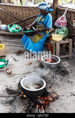 Femme cuisinant sur un feu ouvert, centre d'algues, coopérative de femmes, culture d'algues et production de savon, Paje, East Coast Unguja, Zanzibar Banque D'Images