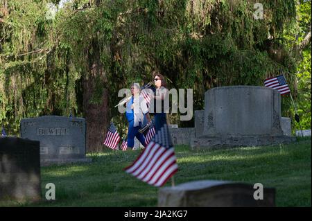 Dallas, États-Unis. 25th mai 2022. Les volontaires portent des drapeaux dans un cimetière tandis qu'ils recherchent des drapeaux qui doivent être remplacés pour le jour du souvenir les membres de la Légion américaine, les scouts et les éclaireuses ont remplacé les drapeaux en lambeaux dans les cimetières en préparation pour le jour du souvenir. Crédit : SOPA Images Limited/Alamy Live News Banque D'Images