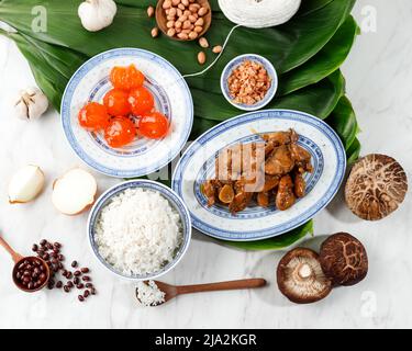 Préparation d'ingrédients Bakcang Zongzi, délicieux riz traditionnel Dumpling nourriture pour le Dragon Boat Duanwu Festival sur les feuilles de bambou Bacang Wrapping, WHI Banque D'Images