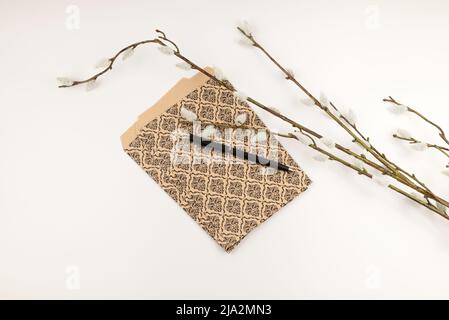 Branche de Salix caprea avec sacs-cadeaux en papier marron à motifs. Banque D'Images