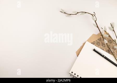 Branche de Salix caprea avec sacs-cadeaux en papier marron à motifs. Banque D'Images