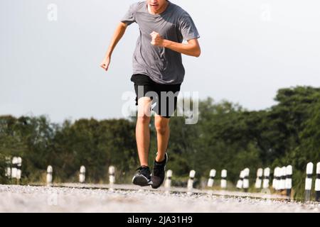 Jeunes hommes coureur pieds courir sur la route être courir pour l'exercice. Concept d'exercice sain. Banque D'Images