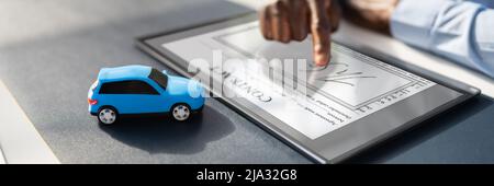 Signature de l'accord de prêt de voiture Contrat avec location de jouet sur Bureau en verre Banque D'Images